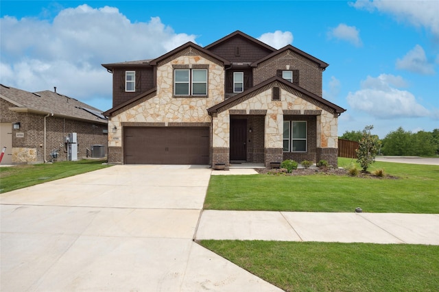 view of front of home featuring driveway, a front yard, cooling unit, an attached garage, and stone siding