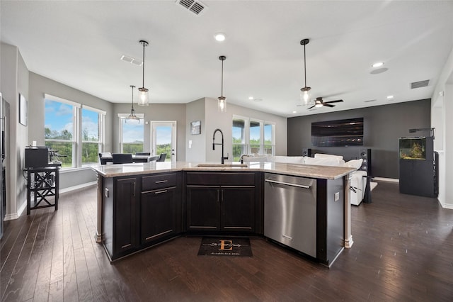 kitchen featuring dark wood-style flooring, visible vents, dishwasher, a sink, and light stone counters