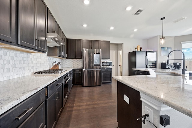 kitchen featuring visible vents, under cabinet range hood, a sink, dark wood finished floors, and stainless steel appliances