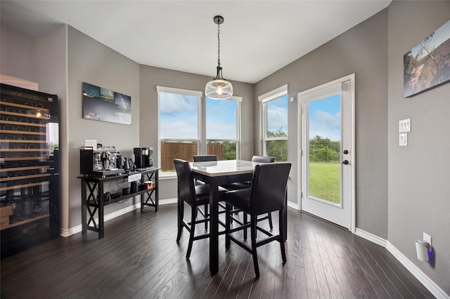 dining space with baseboards, dark wood finished floors, and a wealth of natural light
