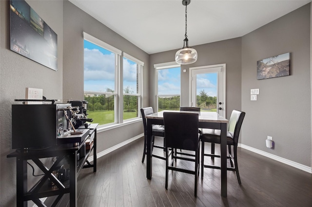 dining area with baseboards and dark wood finished floors