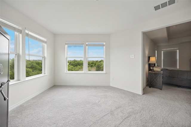 empty room with baseboards, carpet, and visible vents