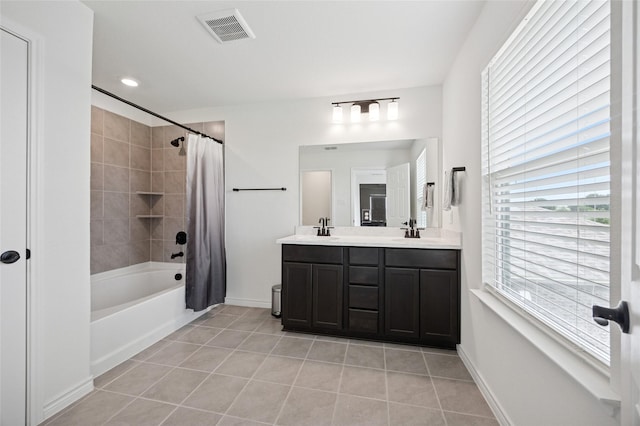 full bathroom featuring double vanity, visible vents, shower / bath combo, a sink, and tile patterned floors