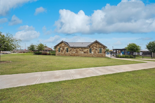 view of front of home with a standing seam roof, metal roof, stone siding, and a front lawn