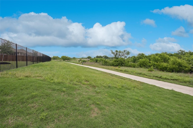 view of community featuring fence and a yard