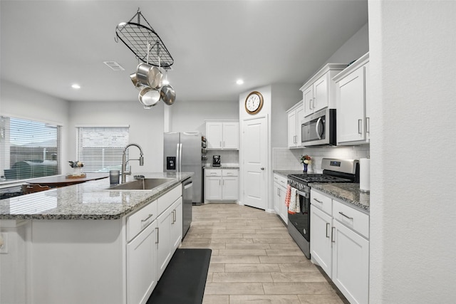 8557 Big Apple Dr, Fort Worth, TX 76179 - kitchen with a sink, white cabinets, visible vents, appliances with stainless steel finishes, and tasteful backsplash