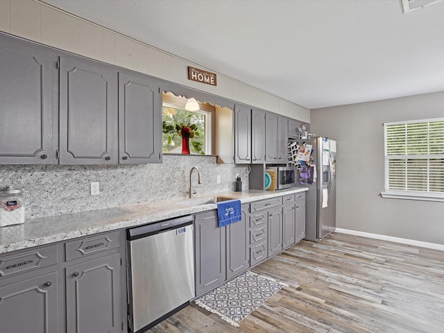 kitchen featuring gray cabinetry, appliances with stainless steel finishes, and decorative backsplash