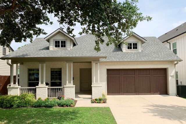 view of front facade with roof with shingles, brick siding, a garage, a porch, and concrete driveway