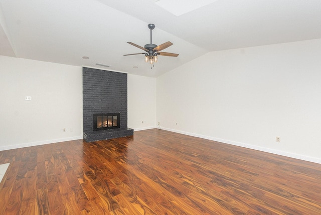 unfurnished living room with ceiling fan, a brick fireplace, dark wood-type flooring, visible vents, and lofted ceiling with skylight