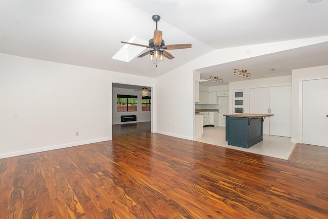 unfurnished living room featuring light wood finished floors, ceiling fan, and lofted ceiling