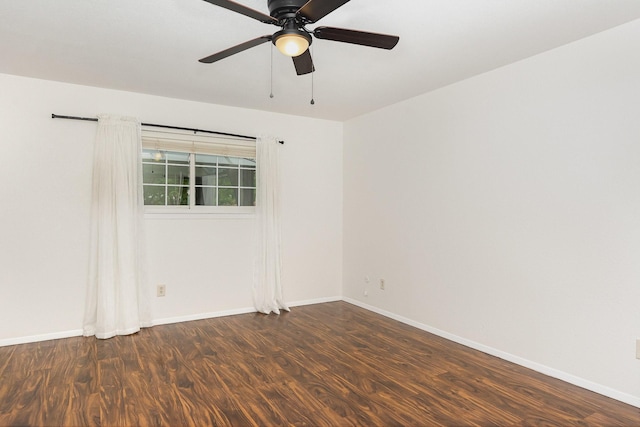 empty room featuring baseboards, a ceiling fan, and dark wood-style floors