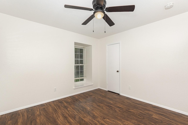 spare room with a ceiling fan, baseboards, and dark wood-style floors