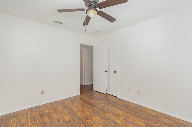 spare room featuring ceiling fan, baseboards, visible vents, and wood finished floors