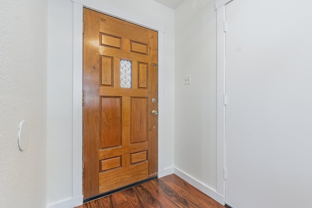 entryway featuring dark wood-style flooring and baseboards