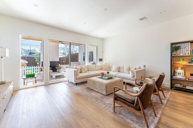 living area with visible vents and light wood-style floors