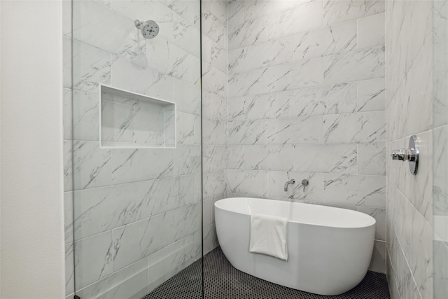 bathroom featuring a tile shower and a soaking tub