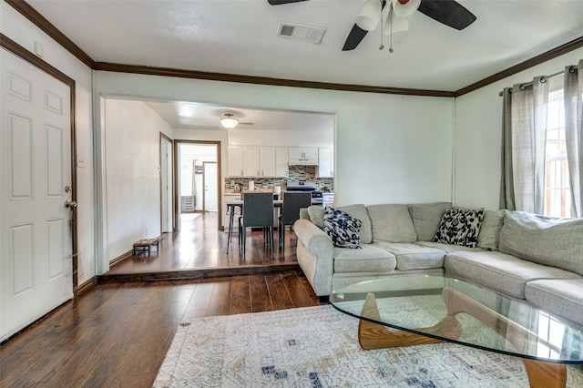 living room featuring ceiling fan, ornamental molding, dark wood finished floors, and visible vents