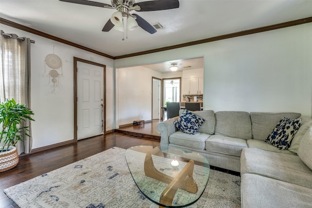 living area with crown molding, ceiling fan, baseboards, wood finished floors, and visible vents