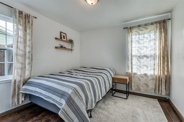 bedroom featuring wood finished floors and multiple windows