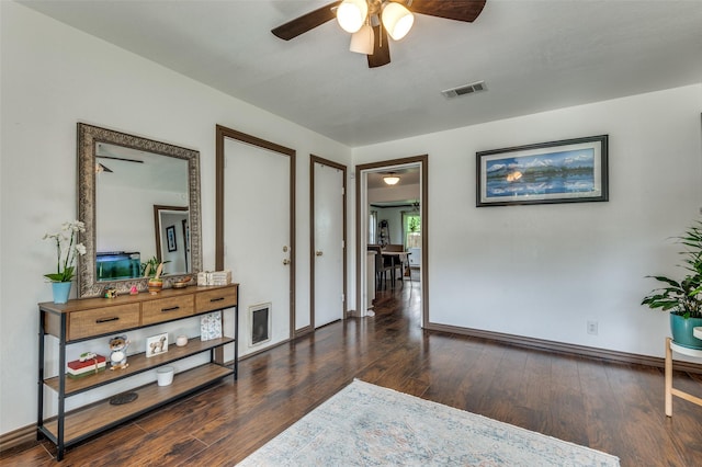 interior space featuring a ceiling fan, baseboards, visible vents, and wood finished floors
