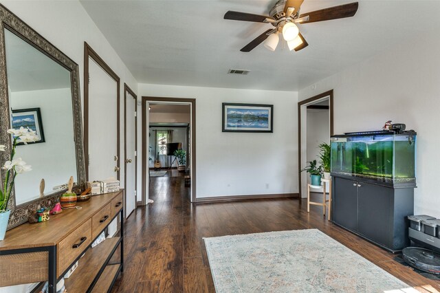 interior space featuring baseboards, ceiling fan, visible vents, and wood finished floors