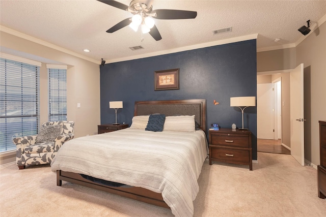 bedroom featuring visible vents, ornamental molding, and light carpet