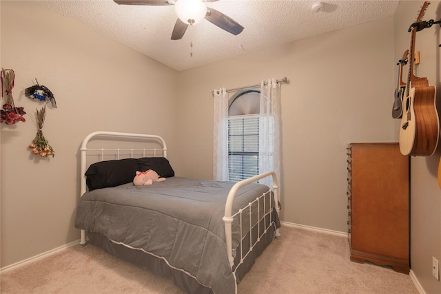 bedroom featuring a ceiling fan, a textured ceiling, and carpet