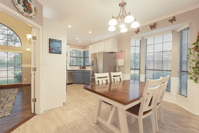 dining room featuring crown molding, a notable chandelier, light wood finished floors, recessed lighting, and baseboards