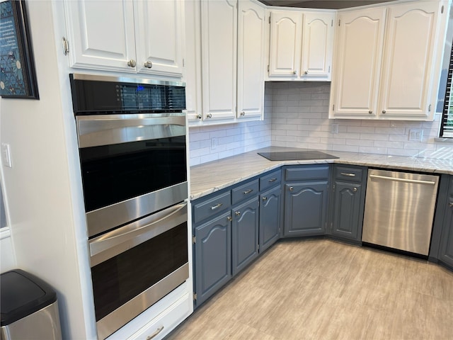 kitchen featuring appliances with stainless steel finishes, white cabinets, and tasteful backsplash
