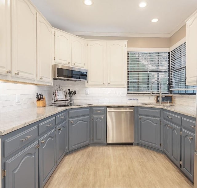 kitchen with a sink, gray cabinets, white cabinetry, and stainless steel appliances