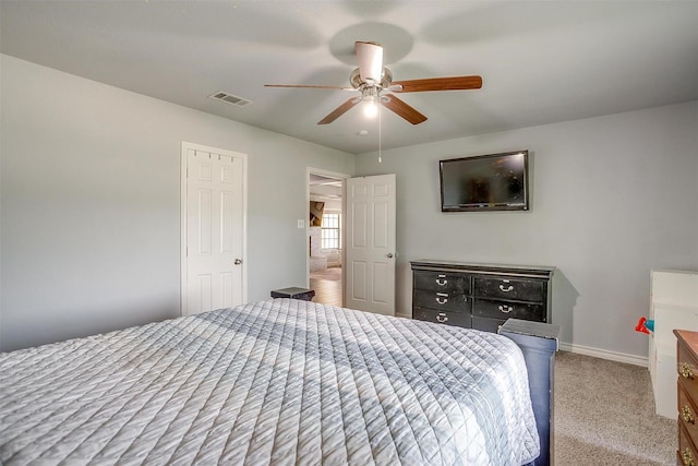 carpeted bedroom with baseboards, a ceiling fan, and visible vents