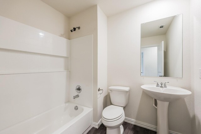 bathroom featuring visible vents, wood finished floors, toilet, baseboards, and bathtub / shower combination