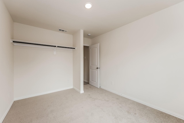 unfurnished bedroom with light colored carpet, baseboards, and visible vents