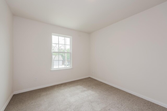 carpeted empty room with baseboards