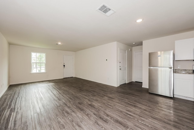 unfurnished living room with visible vents, recessed lighting, baseboards, and dark wood-type flooring