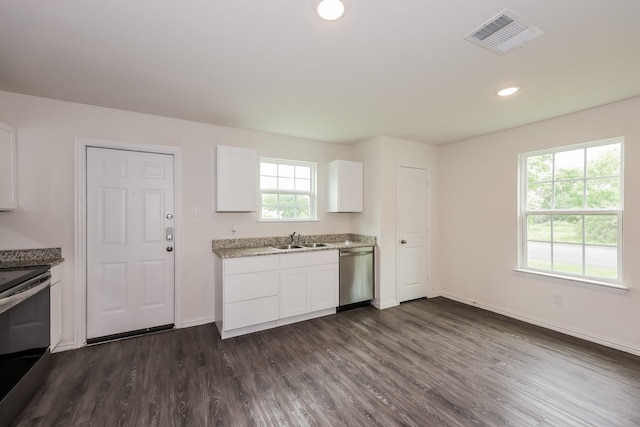kitchen with visible vents, a sink, baseboards, stainless steel appliances, and dark wood-type flooring
