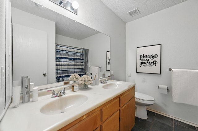 2011 Kalgary Ln, Grand Prairie, TX 75052 - bathroom featuring toilet, double vanity, tile patterned flooring, curtained shower, and a textured ceiling