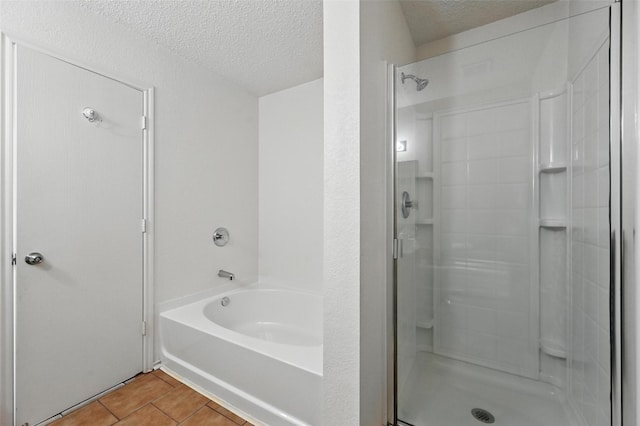 2011 Kalgary Ln, Grand Prairie, TX 75052 - bathroom with a textured ceiling, tile patterned floors, a shower stall, and a garden tub