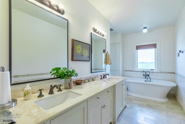 990 County Road 621, Tuscola, TX 79562 - full bath with double vanity, a freestanding tub, a sink, and a wainscoted wall