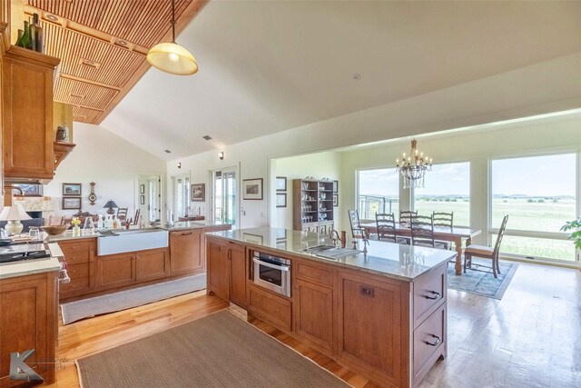 990 County Road 621, Tuscola, TX 79562 - kitchen featuring light wood-type flooring, a sink, lofted ceiling, and a notable chandelier