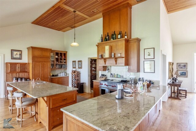 990 County Road 621, Tuscola, TX 79562 - kitchen featuring custom exhaust hood, brown cabinets, high vaulted ceiling, and range with two ovens