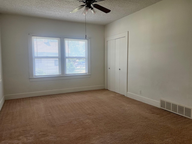 742 Elm St, Graham, TX 76450 - unfurnished bedroom featuring light carpet, a textured ceiling, baseboards, and visible vents