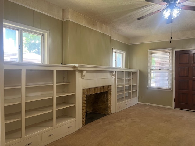 742 Elm St, Graham, TX 76450 - unfurnished living room featuring a ceiling fan, a textured ceiling, a fireplace, and carpet