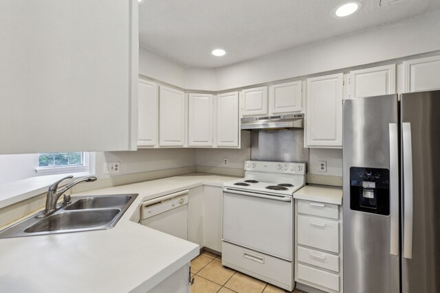 kitchen with white appliances, light countertops, under cabinet range hood, white cabinets, and a sink