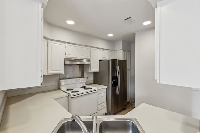kitchen with visible vents, white electric range, light countertops, stainless steel fridge with ice dispenser, and under cabinet range hood