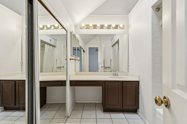 bathroom with vanity, tile patterned flooring, vaulted ceiling, and curtained shower