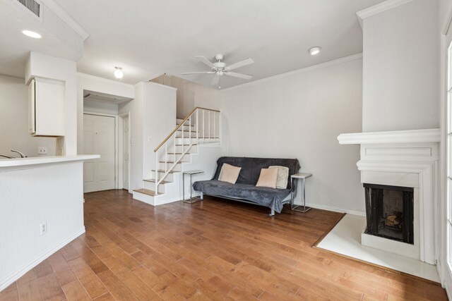 sitting room with light wood-style flooring, a ceiling fan, baseboards, visible vents, and stairway