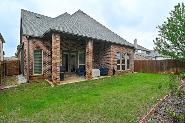back of house with a shingled roof, brick siding, a fenced backyard, a patio area, and french doors