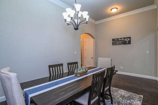 dining space with crown molding, arched walkways, wood finished floors, baseboards, and a notable chandelier