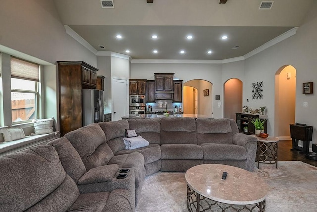 living room featuring crown molding, arched walkways, recessed lighting, wood finished floors, and visible vents